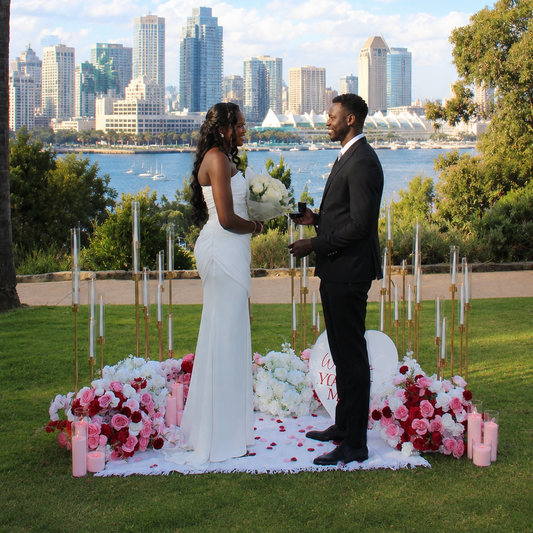 Romantic proposal moment with floral arrangement, candles and San Diego downtown skyline – Granada Floral Design