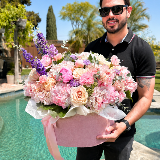 Man holding a large bouquet of flowers by a pool