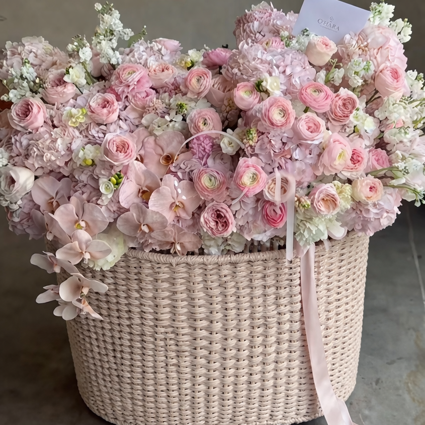 Basket of pink and white flowers on a gray floor
