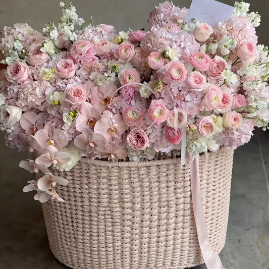 Basket of pink and white flowers on a gray floor