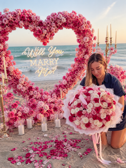 Pink floral heart arch beach proposal with luxury rose bouquet and candles at sunset – Granada Floral San Diego
