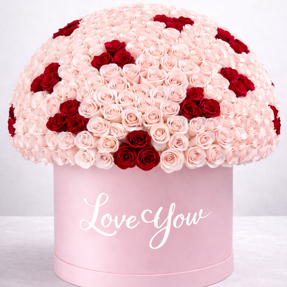 Pink and red rose arrangement in a box with 'Love You' text on a white background