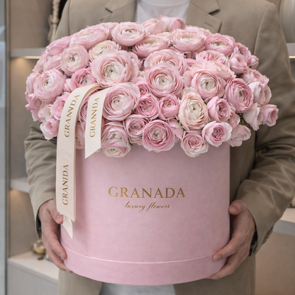 Man holding a pink flower box with 'Granada' branding