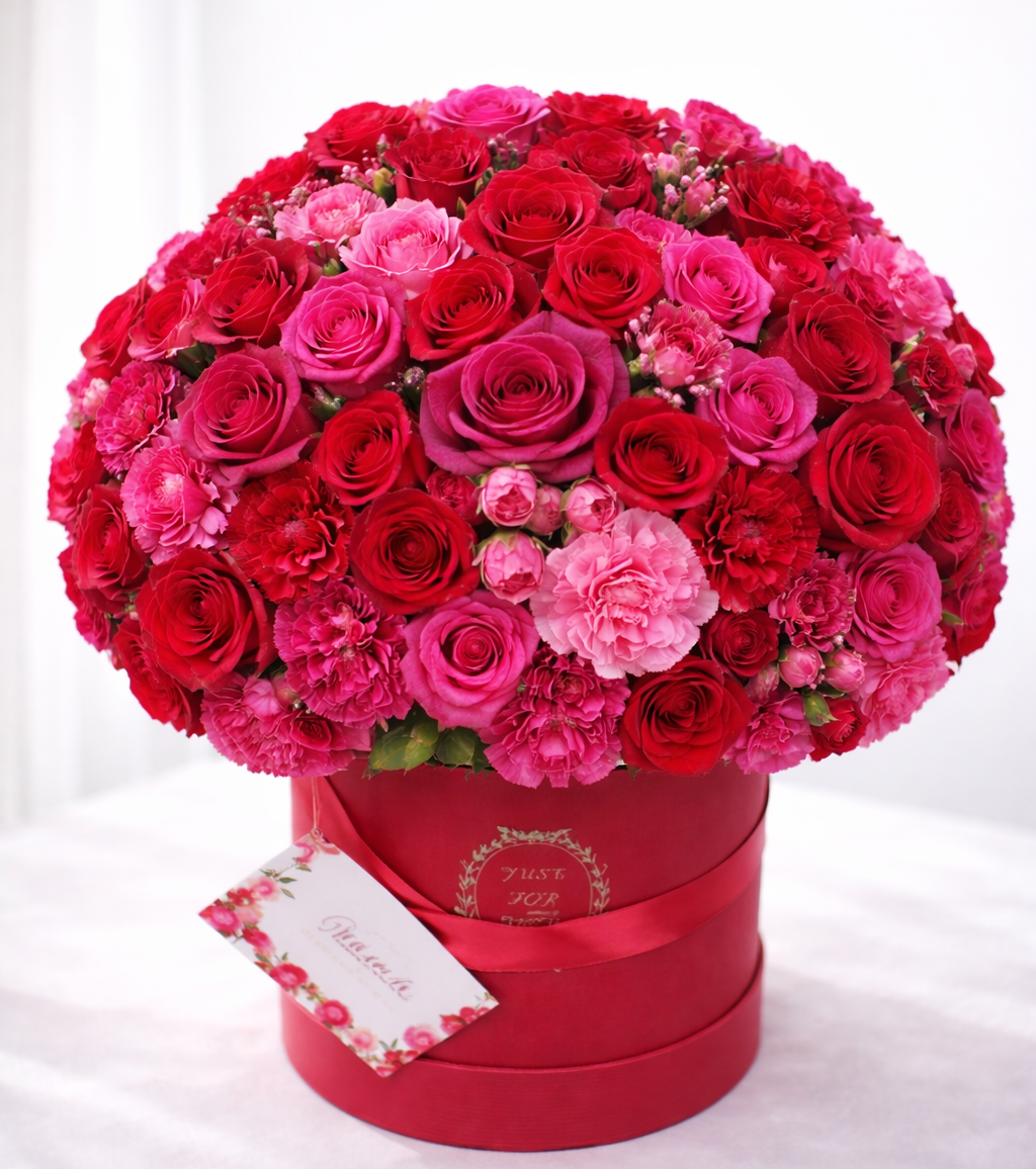 Bouquet of red and pink roses in a red box on a white background